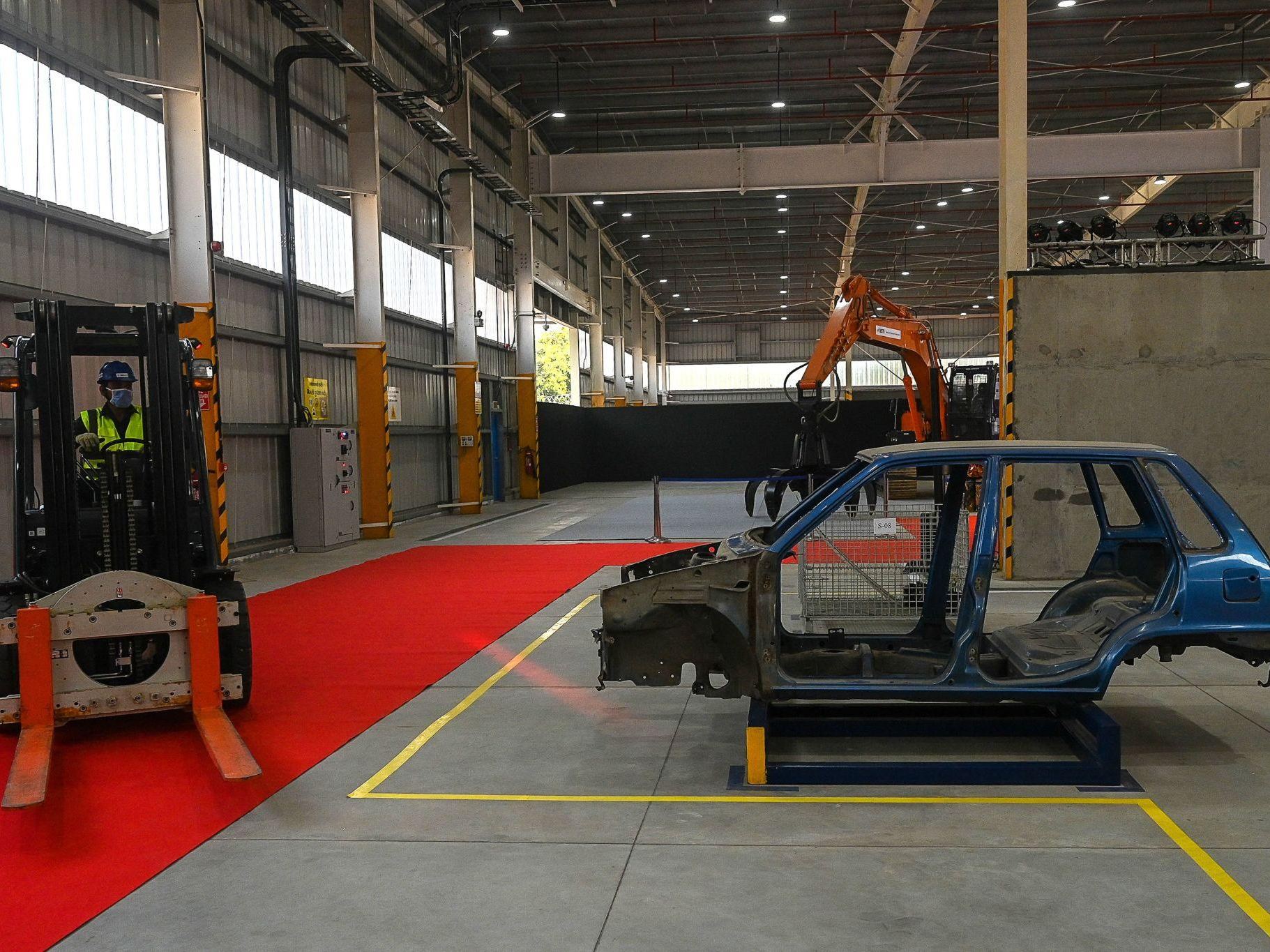 A stripped vehicle shell on the floor of a vehicle scrapping facility