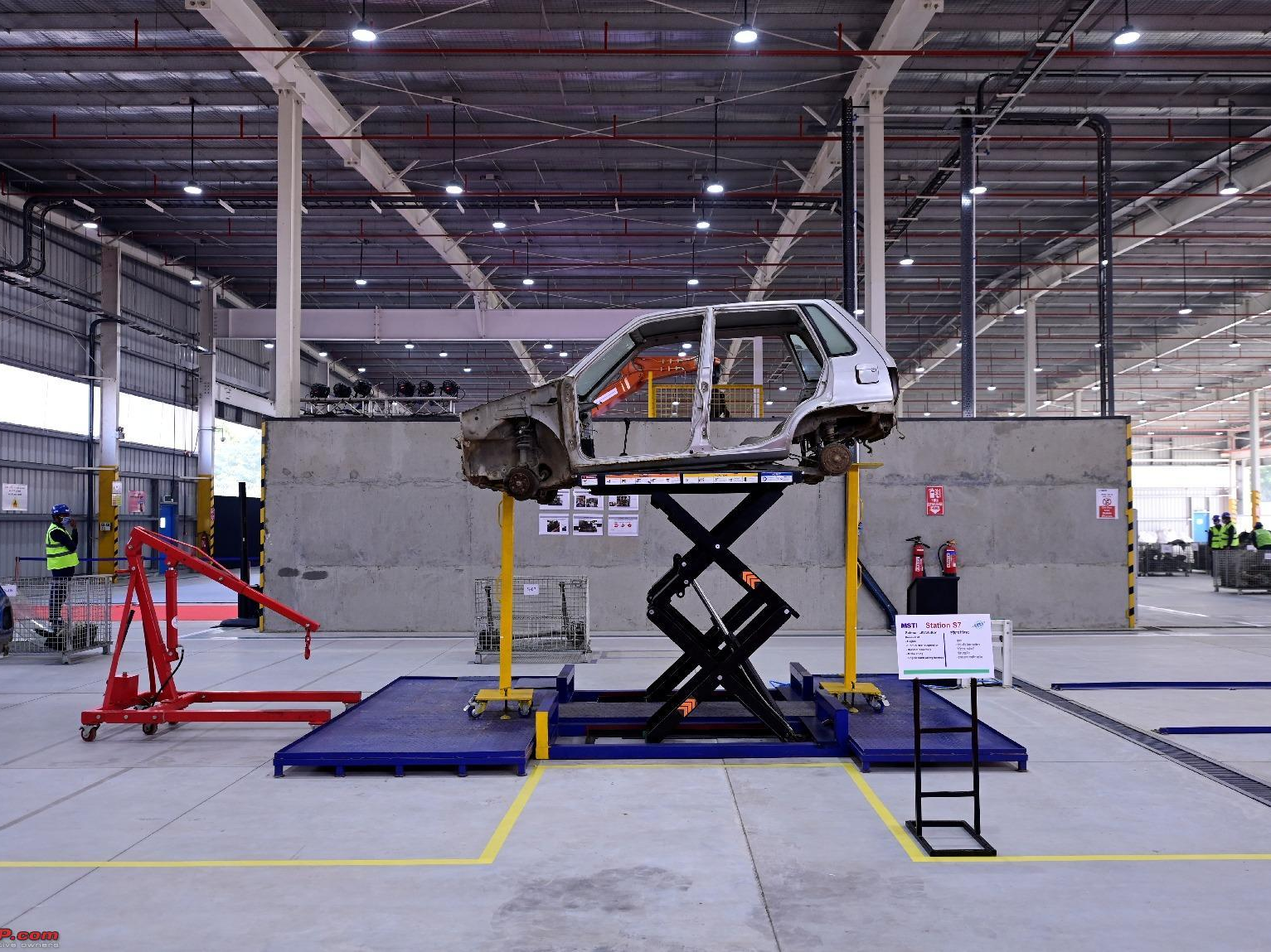 A vehicle body raised on a scissor lift at a dismantling station